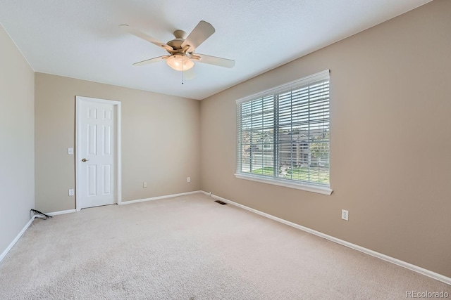 unfurnished room featuring light colored carpet and ceiling fan