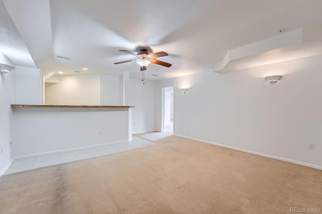 unfurnished living room featuring a textured ceiling, light colored carpet, and ceiling fan