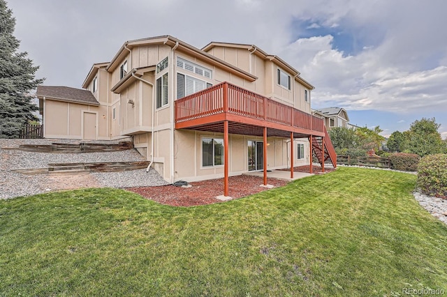 rear view of property featuring a patio, a wooden deck, and a lawn