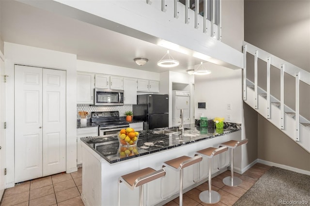 kitchen with sink, white cabinetry, decorative light fixtures, kitchen peninsula, and stainless steel appliances