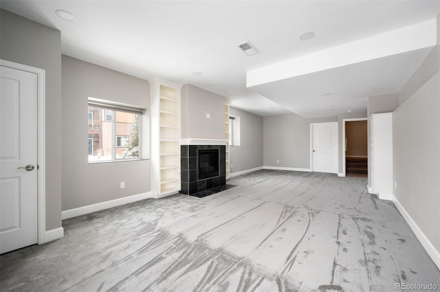 unfurnished living room with light carpet, baseboards, visible vents, and a tile fireplace