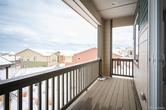 snow covered back of property featuring a residential view