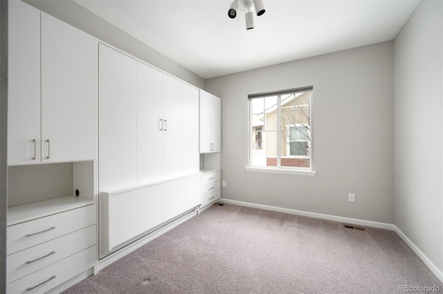 unfurnished room with light carpet and baseboards