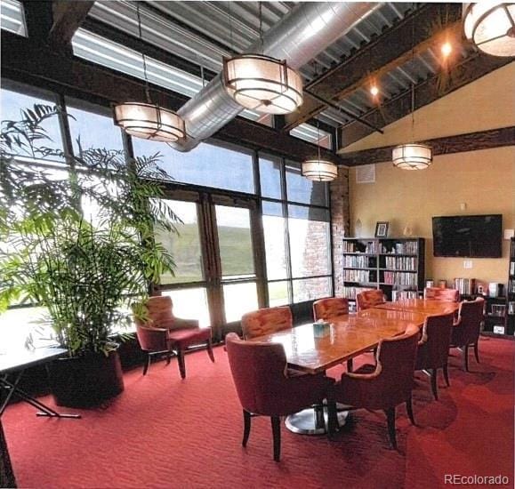 carpeted dining room with a towering ceiling