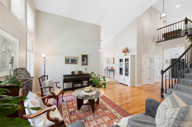 85 Willowleaf Dr, Littleton, CO 80127 - living room featuring high vaulted ceiling, light wood-style flooring, stairway, and baseboards