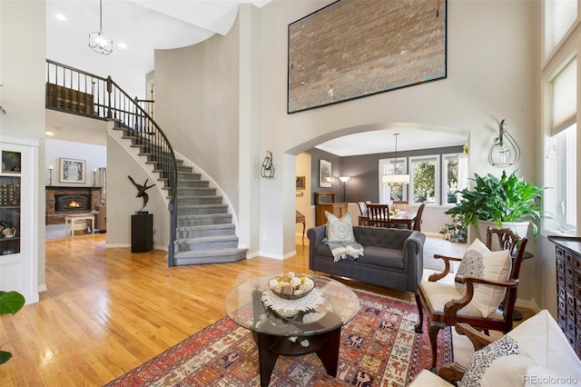 85 Willowleaf Dr, Littleton, CO 80127 - living area with a high ceiling, arched walkways, light wood finished floors, stairs, and baseboards