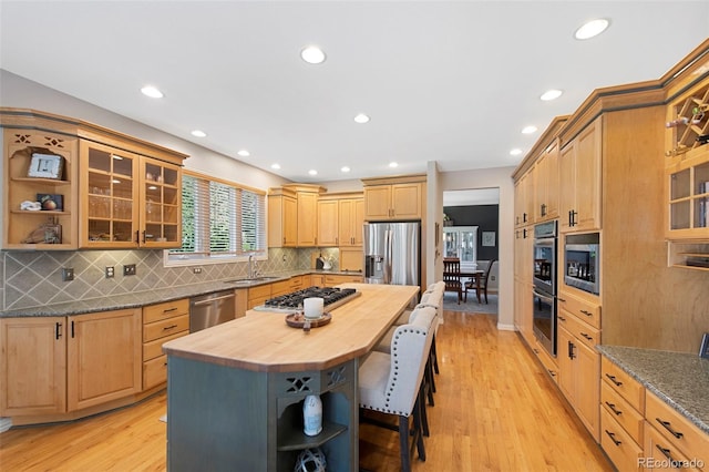 85 Willowleaf Dr, Littleton, CO 80127 - kitchen featuring butcher block countertops, open shelves, stainless steel appliances, a sink, and a kitchen bar