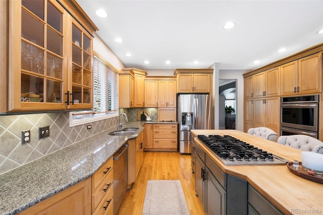 85 Willowleaf Dr, Littleton, CO 80127 - kitchen featuring appliances with stainless steel finishes, a sink, light wood-style flooring, recessed lighting, and light stone countertops