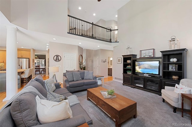 85 Willowleaf Dr, Littleton, CO 80127 - living room with ornate columns, a towering ceiling, recessed lighting, and light colored carpet