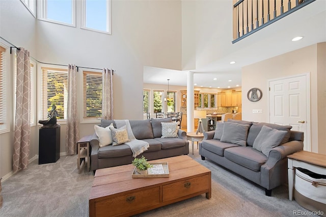 85 Willowleaf Dr, Littleton, CO 80127 - carpeted living area featuring ornate columns, a towering ceiling, recessed lighting, and baseboards