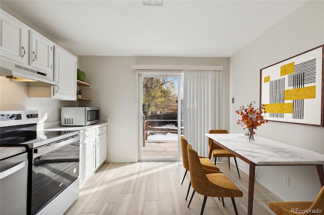 kitchen with white cabinets, light wood-type flooring, and stainless steel appliances