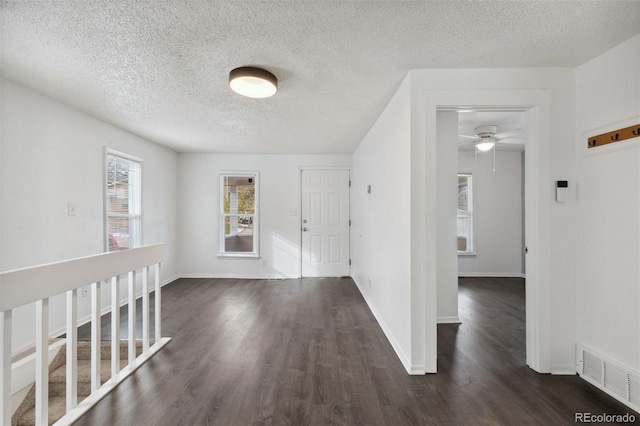 hall with dark hardwood / wood-style floors and a textured ceiling