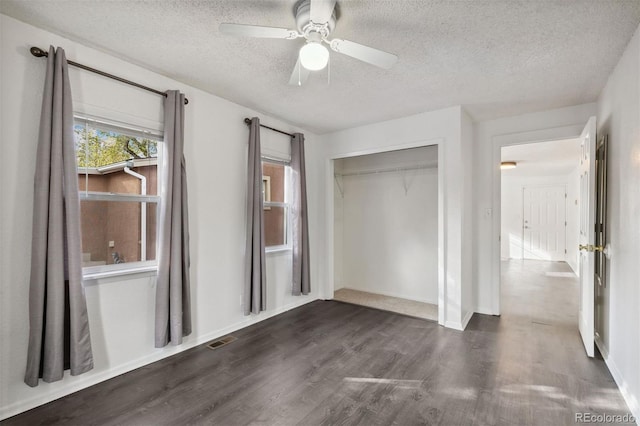 unfurnished bedroom with a textured ceiling, a closet, ceiling fan, and dark wood-type flooring