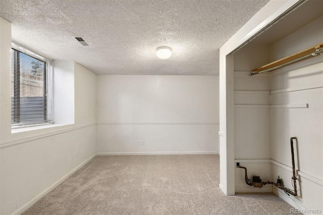 interior space featuring light carpet and a textured ceiling