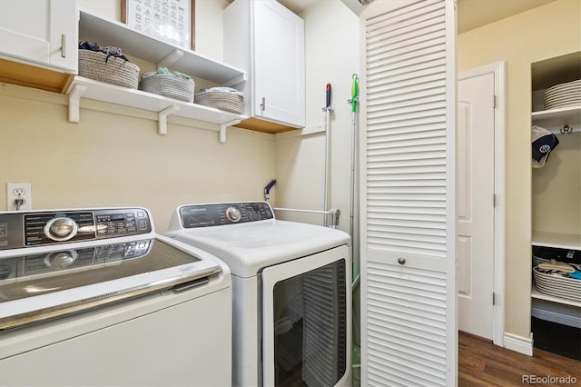 laundry area featuring dark wood-type flooring, cabinets, and washer and clothes dryer