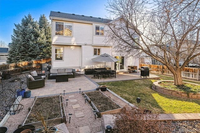 back of property with outdoor lounge area, a patio area, and a lawn