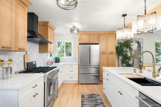 6512 Upham St, Arvada, CO 80003 - kitchen with appliances with stainless steel finishes, wall chimney exhaust hood, a sink, and healthy amount of natural light
