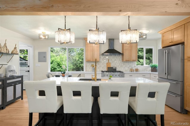6512 Upham St, Arvada, CO 80003 - kitchen with high end fridge, wall chimney range hood, a chandelier, and light wood-style flooring