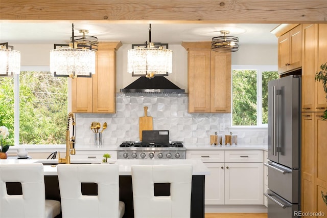 6512 Upham St, Arvada, CO 80003 - kitchen with high quality fridge, a chandelier, light countertops, backsplash, and light brown cabinetry
