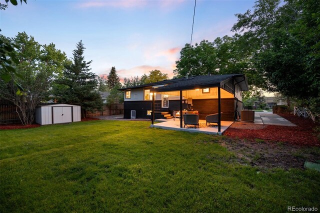 6512 Upham St, Arvada, CO 80003 - back of house at dusk featuring a patio, central AC, and an outdoor hangout area