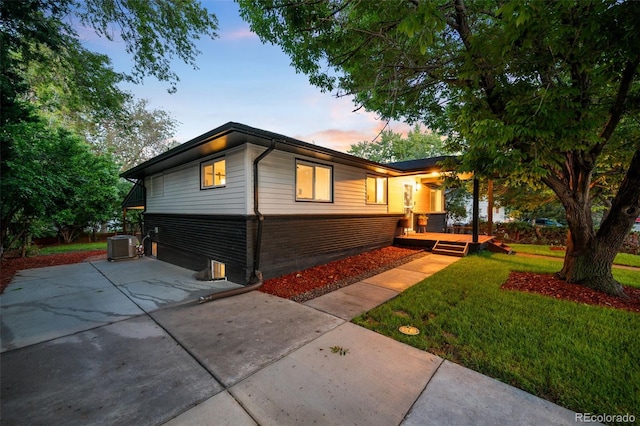 6512 Upham St, Arvada, CO 80003 - view of front of property featuring a yard, concrete driveway, central AC unit, and a patio area