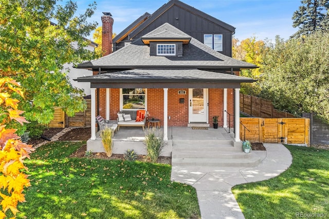 exterior space featuring covered porch and a front lawn