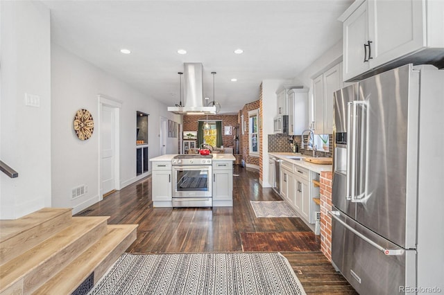 kitchen featuring stainless steel appliances, dark hardwood / wood-style floors, decorative light fixtures, island range hood, and white cabinets