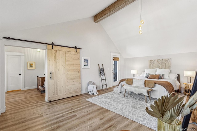 bedroom featuring beamed ceiling, a barn door, light hardwood / wood-style floors, and high vaulted ceiling