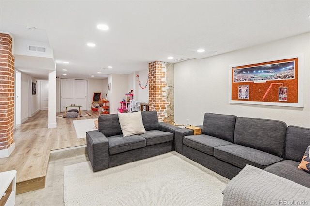 living room with decorative columns and light wood-type flooring