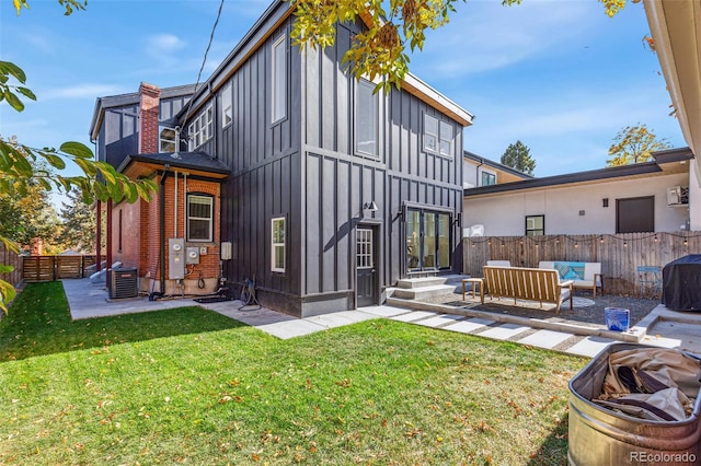 back of property with a yard, an outdoor hangout area, and a patio area