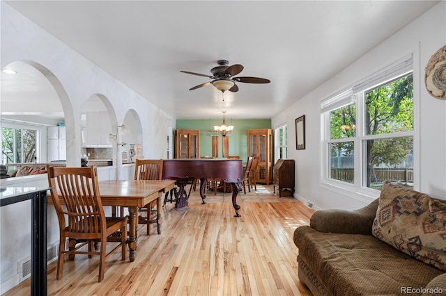interior space with arched walkways, light wood-style flooring, and a healthy amount of sunlight