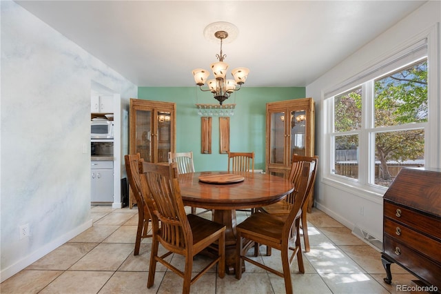 dining area featuring baseboards, a chandelier, light tile patterned floors, and visible vents