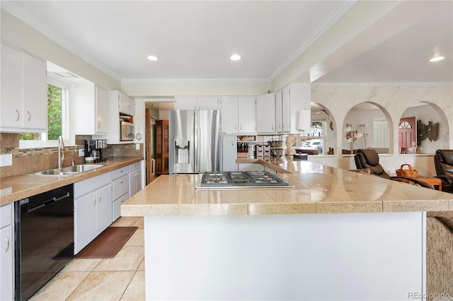 kitchen featuring crown molding, light tile patterned flooring, a sink, stainless steel appliances, and tile countertops