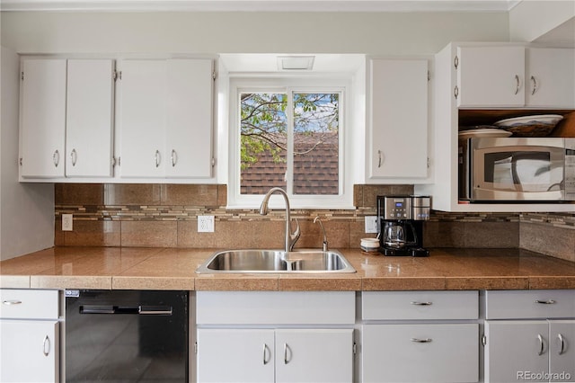 kitchen with black dishwasher, tile countertops, stainless steel microwave, white cabinets, and a sink