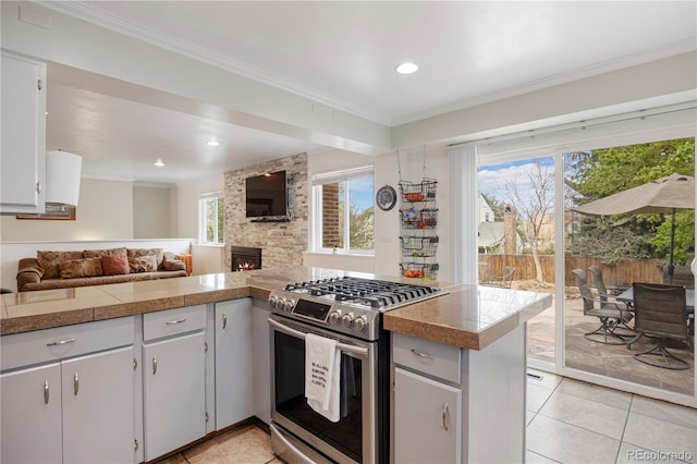 kitchen featuring light tile patterned floors, tile counters, plenty of natural light, and gas range