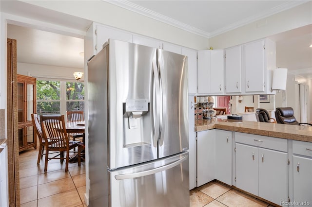 kitchen featuring white cabinets, crown molding, stainless steel fridge, and light tile patterned floors