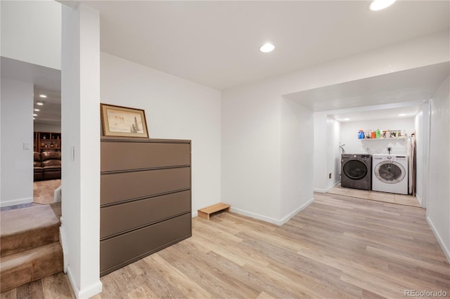 clothes washing area featuring light wood finished floors, laundry area, recessed lighting, and washer and dryer