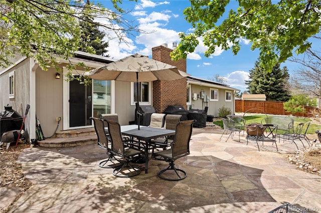 view of patio with entry steps, fence, and outdoor dining space