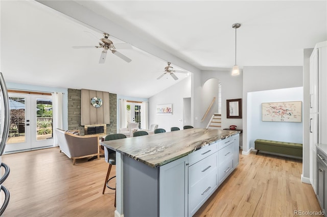 7767 S Depew St, Littleton, CO 80128 - kitchen with a kitchen bar, plenty of natural light, open floor plan, and light wood-style floors