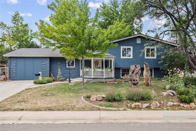 7767 S Depew St, Littleton, CO 80128 - split level home with covered porch, a front yard, concrete driveway, and a garage