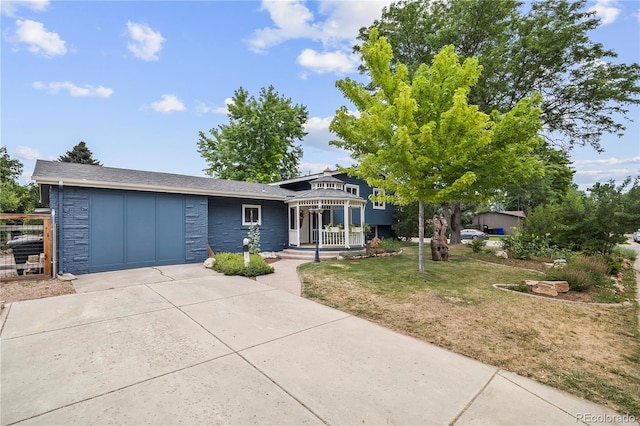 7767 S Depew St, Littleton, CO 80128 - view of front of house with driveway, an attached garage, a front lawn, and stone siding