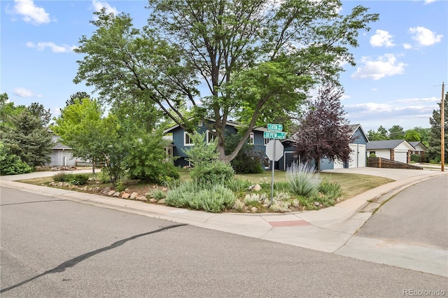 7767 S Depew St, Littleton, CO 80128 - view of property hidden behind natural elements with a detached garage and concrete driveway