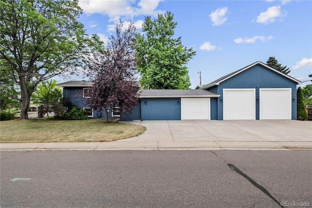 7767 S Depew St, Littleton, CO 80128 - view of front of house featuring a front lawn, a garage, and concrete driveway