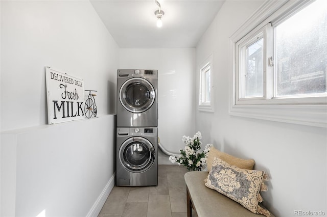 laundry area featuring light tile patterned flooring, laundry area, and stacked washer / dryer