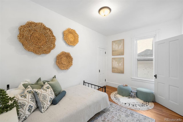 bedroom featuring wood finished floors and baseboards