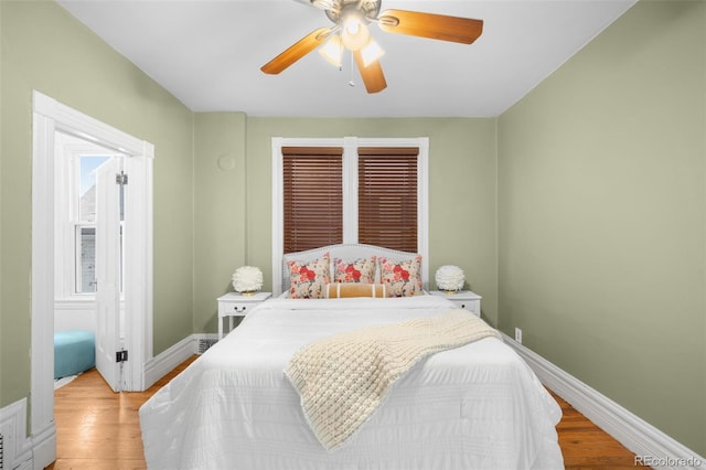 bedroom with a ceiling fan, light wood-style floors, and baseboards