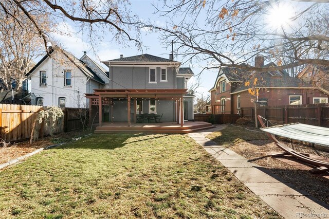 rear view of house featuring a yard, a deck, and a fenced backyard