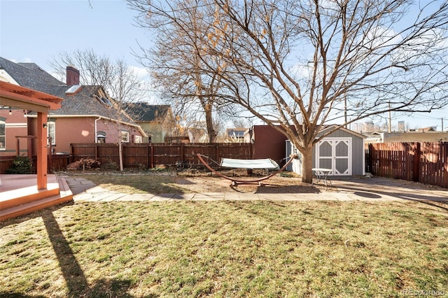 view of yard with a patio area, an outdoor structure, a storage shed, and a fenced backyard