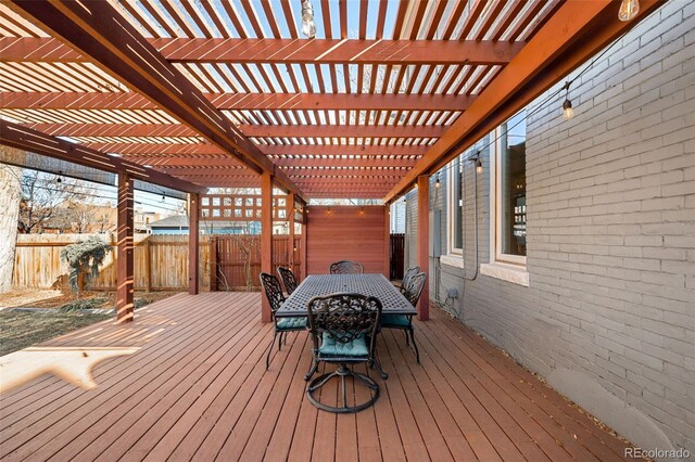 wooden deck with outdoor dining area, fence, and a pergola