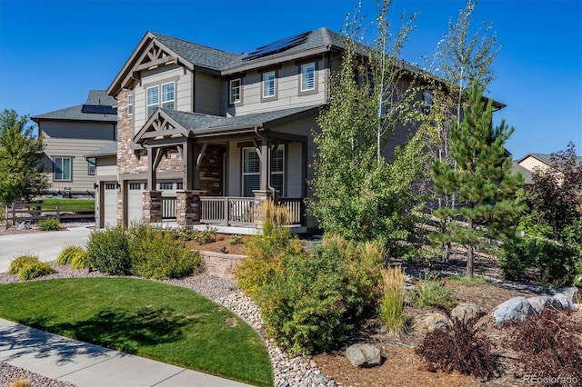 view of front of property featuring a front yard, a garage, and covered porch